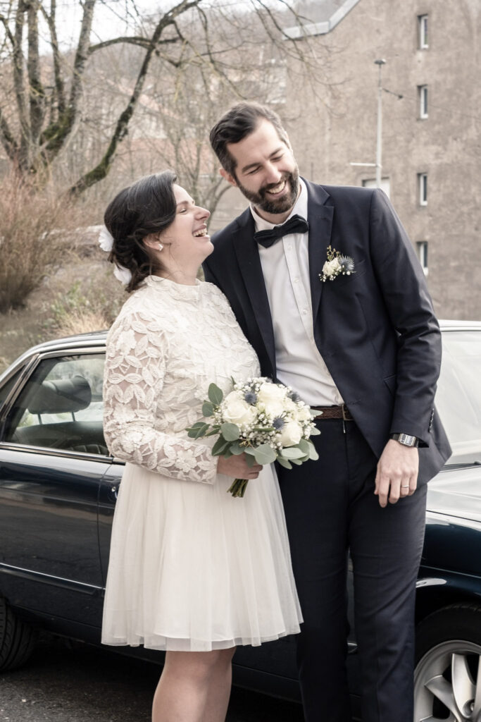 couple de mariés souriants a la sortie de l'église